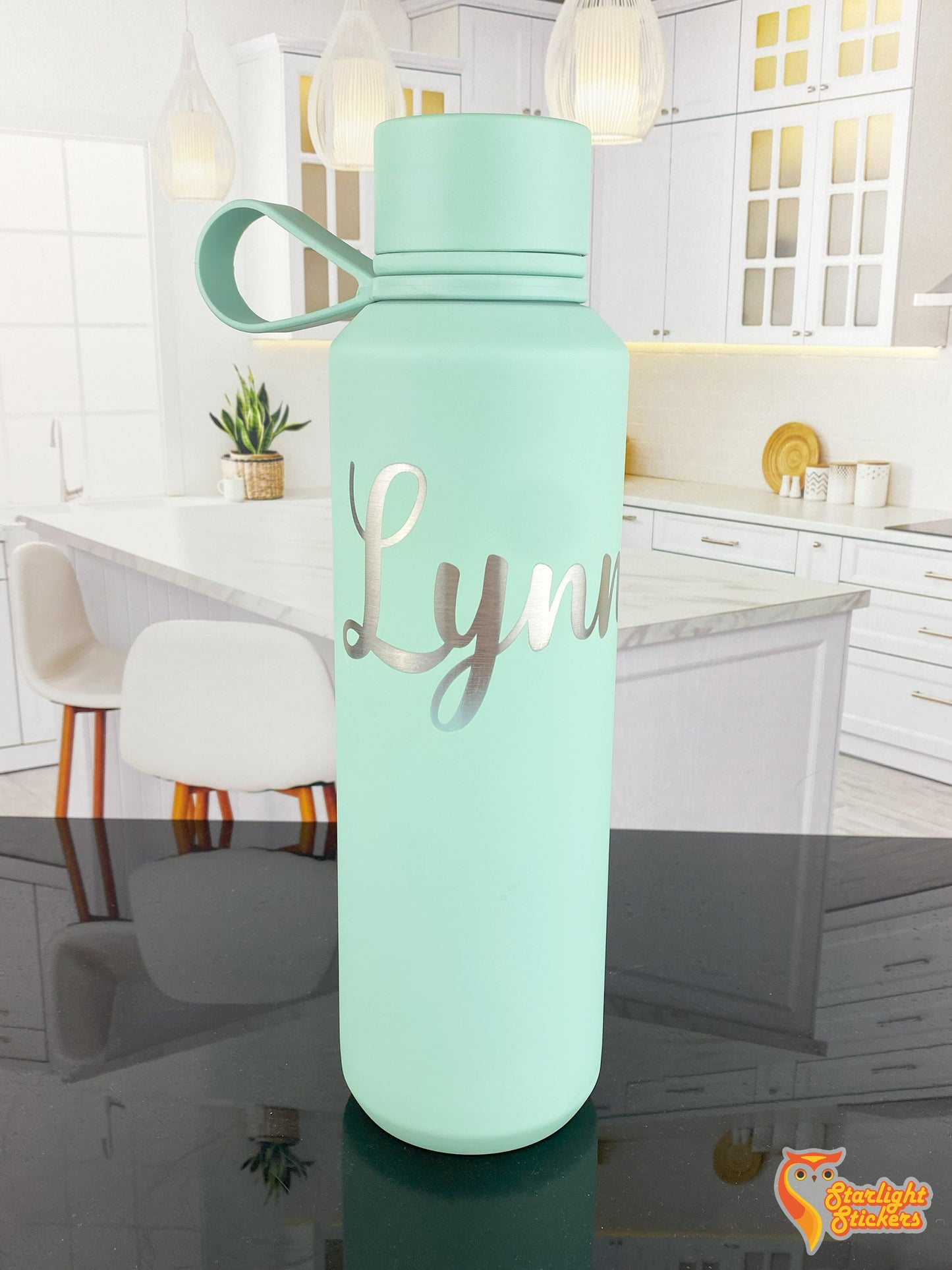 Engraved mint tumbler on a black reflective table.
