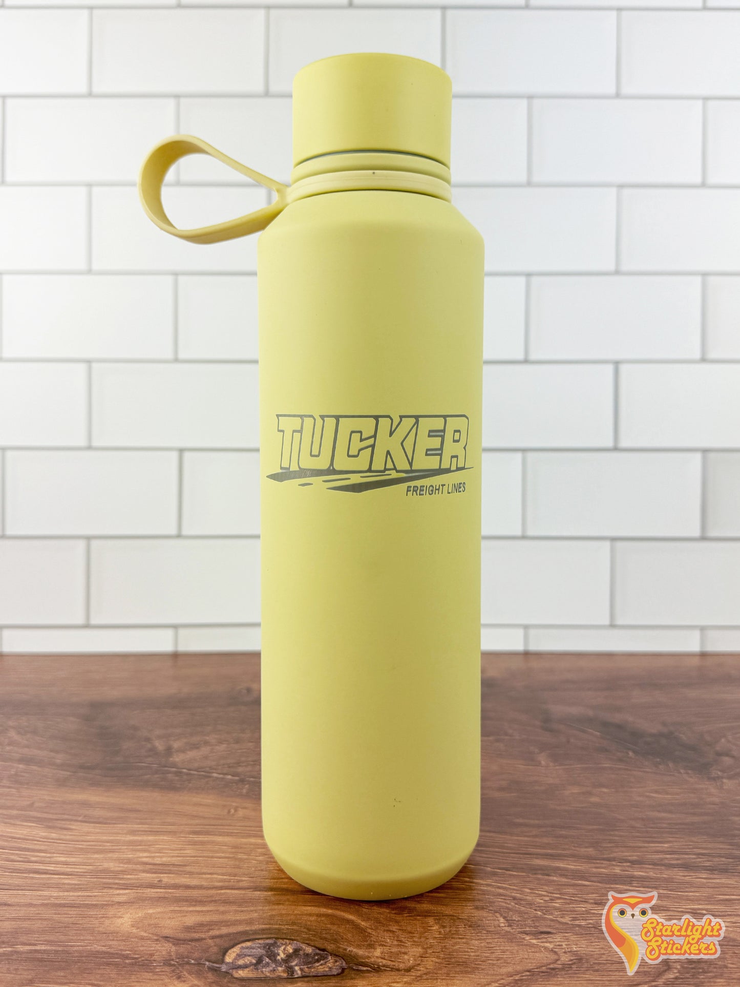 Engraved yellow tumbler on a wooden table.