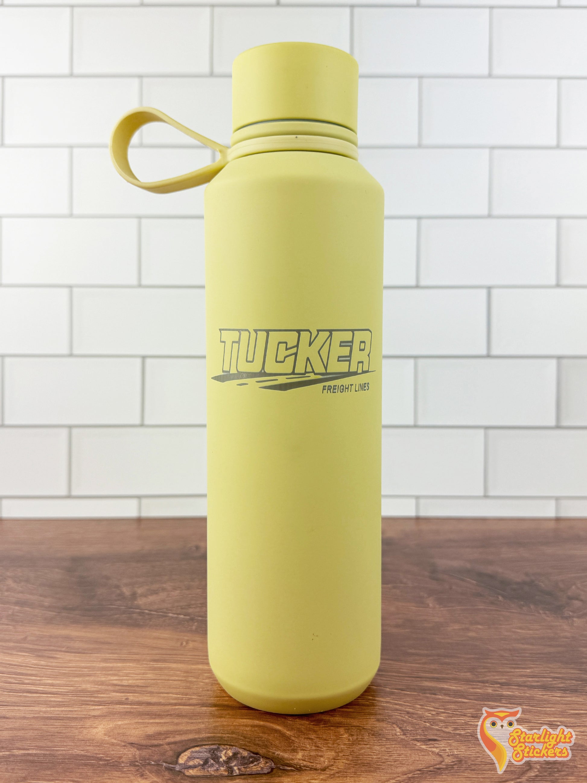 Engraved yellow tumbler on a wooden table.