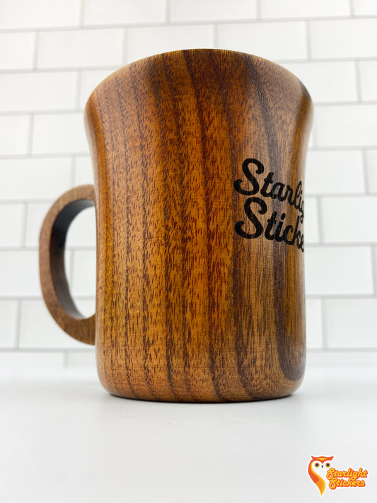 Close up of engraved wooden mug with a white tile background.