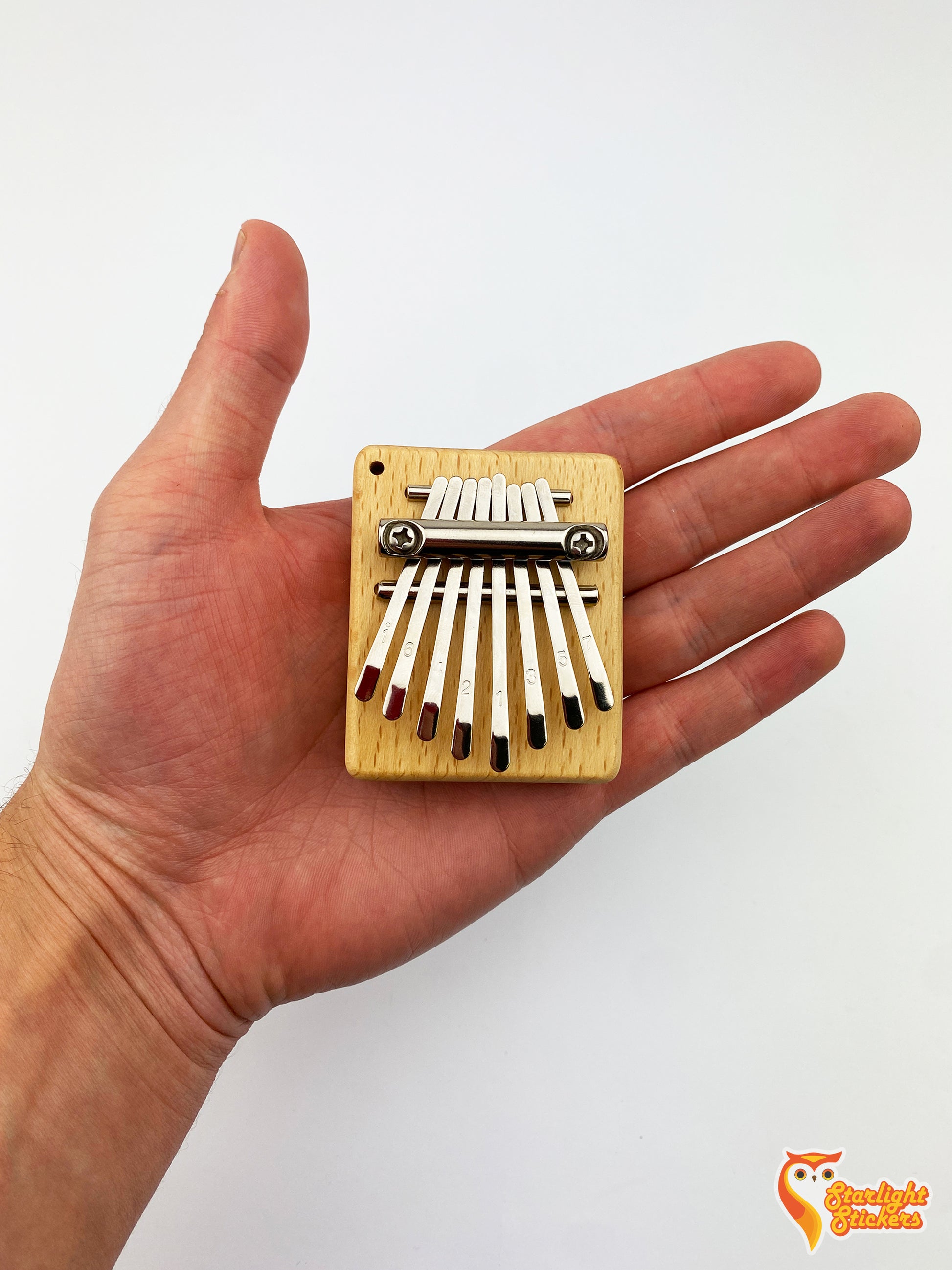Pocket kalimba in the palm of a hand.