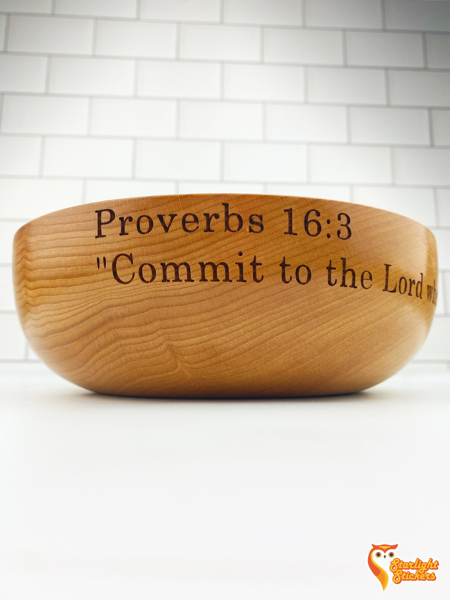 Engraved wooden bowl on a white table.
