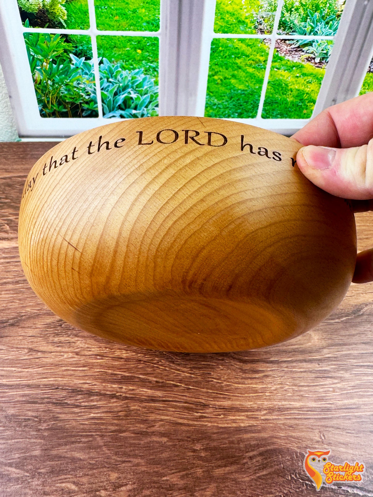 Hand holding wooden bowl.