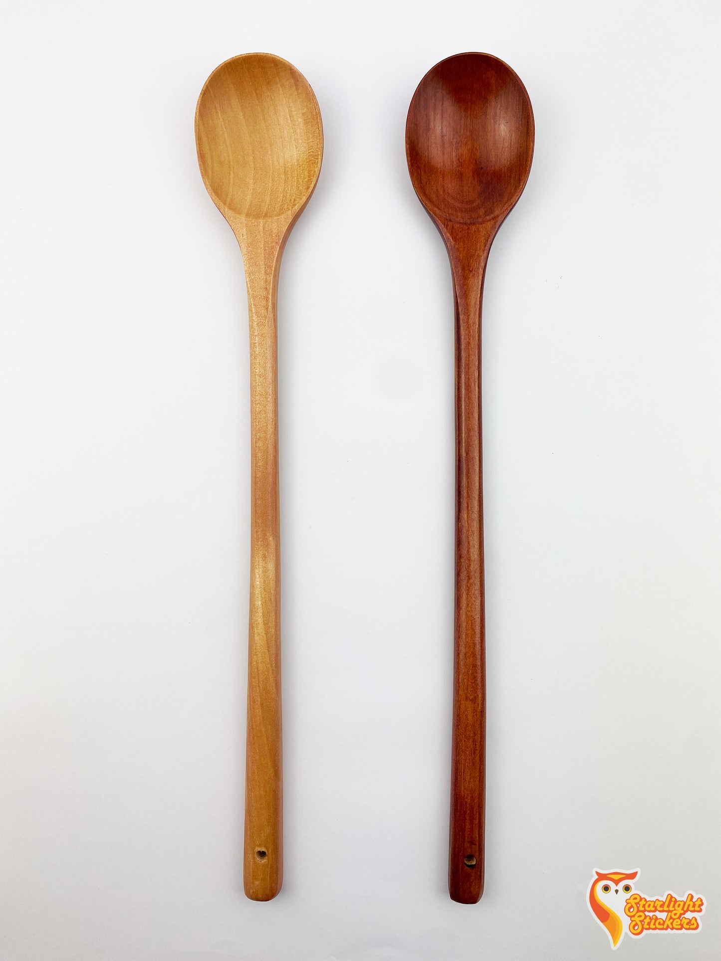 two plain spoons, one is light wood the other is dark wood.