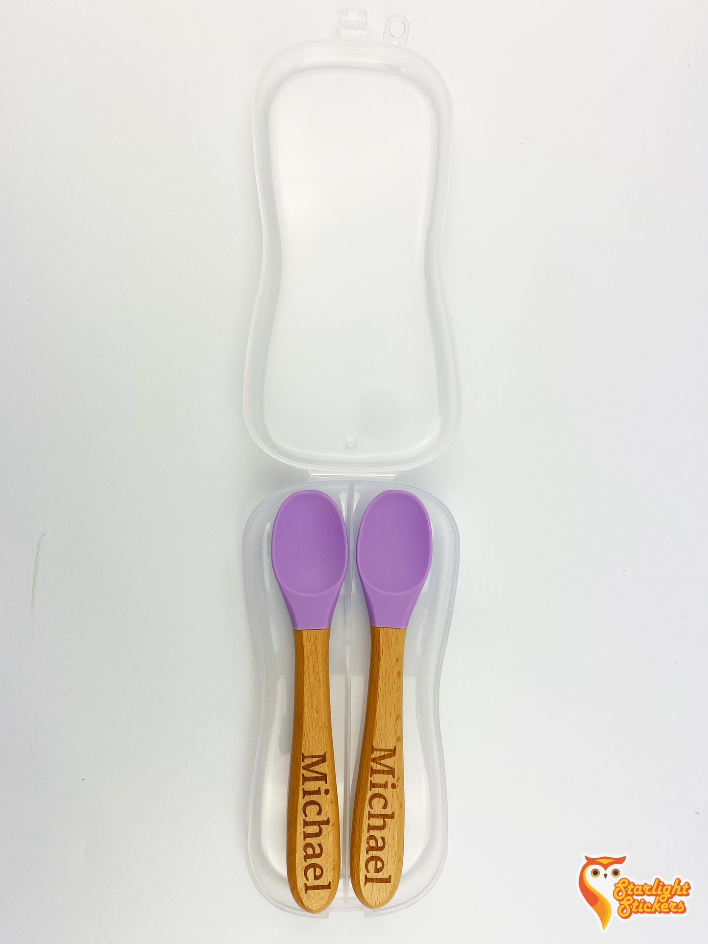 Two baby spoons with engraved names on the handles with a white background.