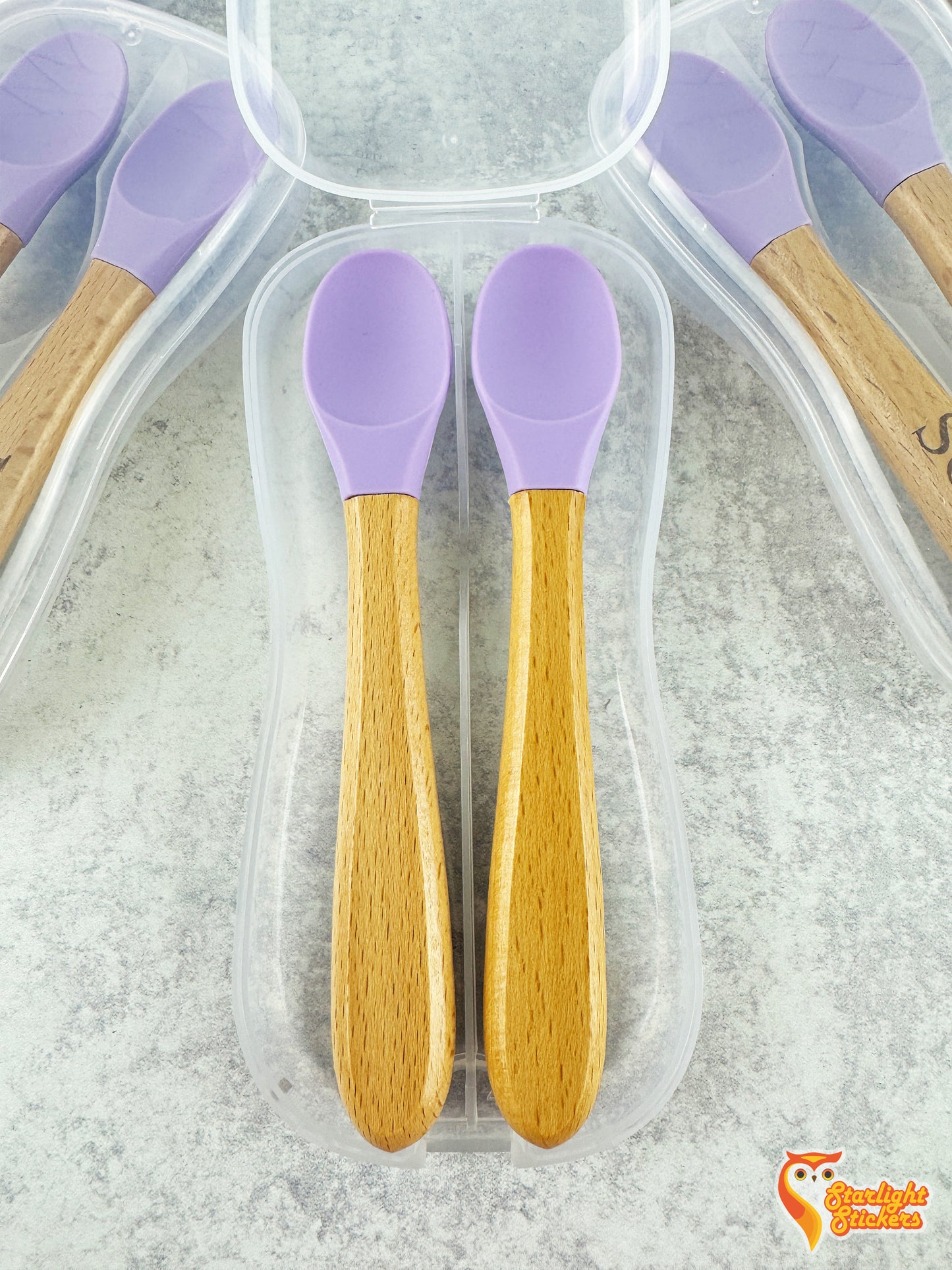 2 baby spoons in an open clear plastic travel case.