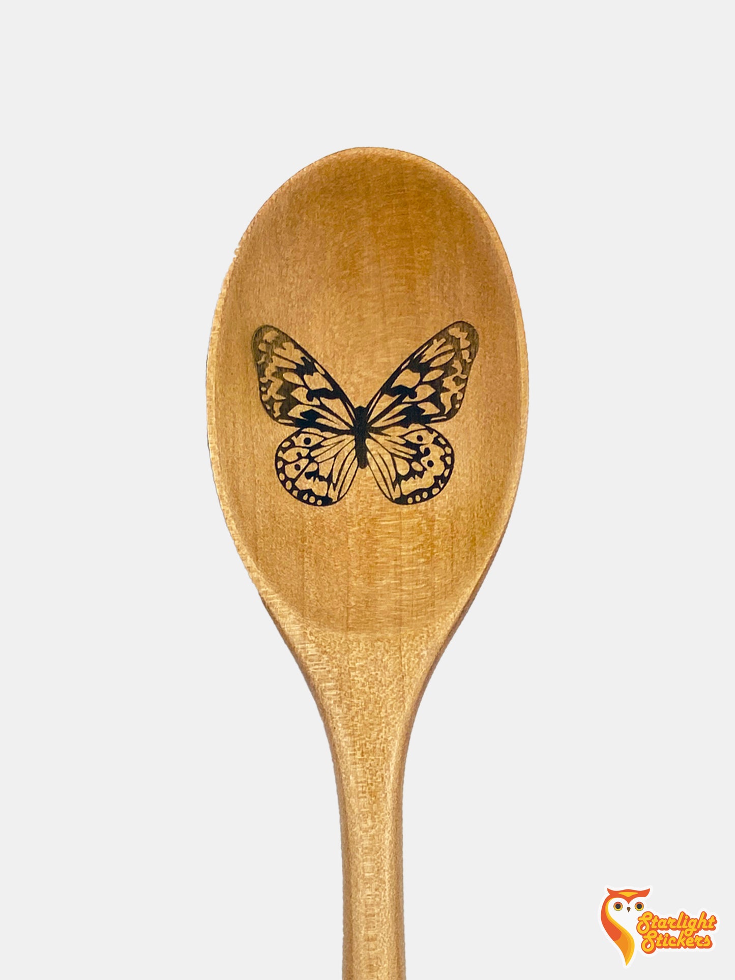 Butterfly engraved in the spoon of a light wood spoon.