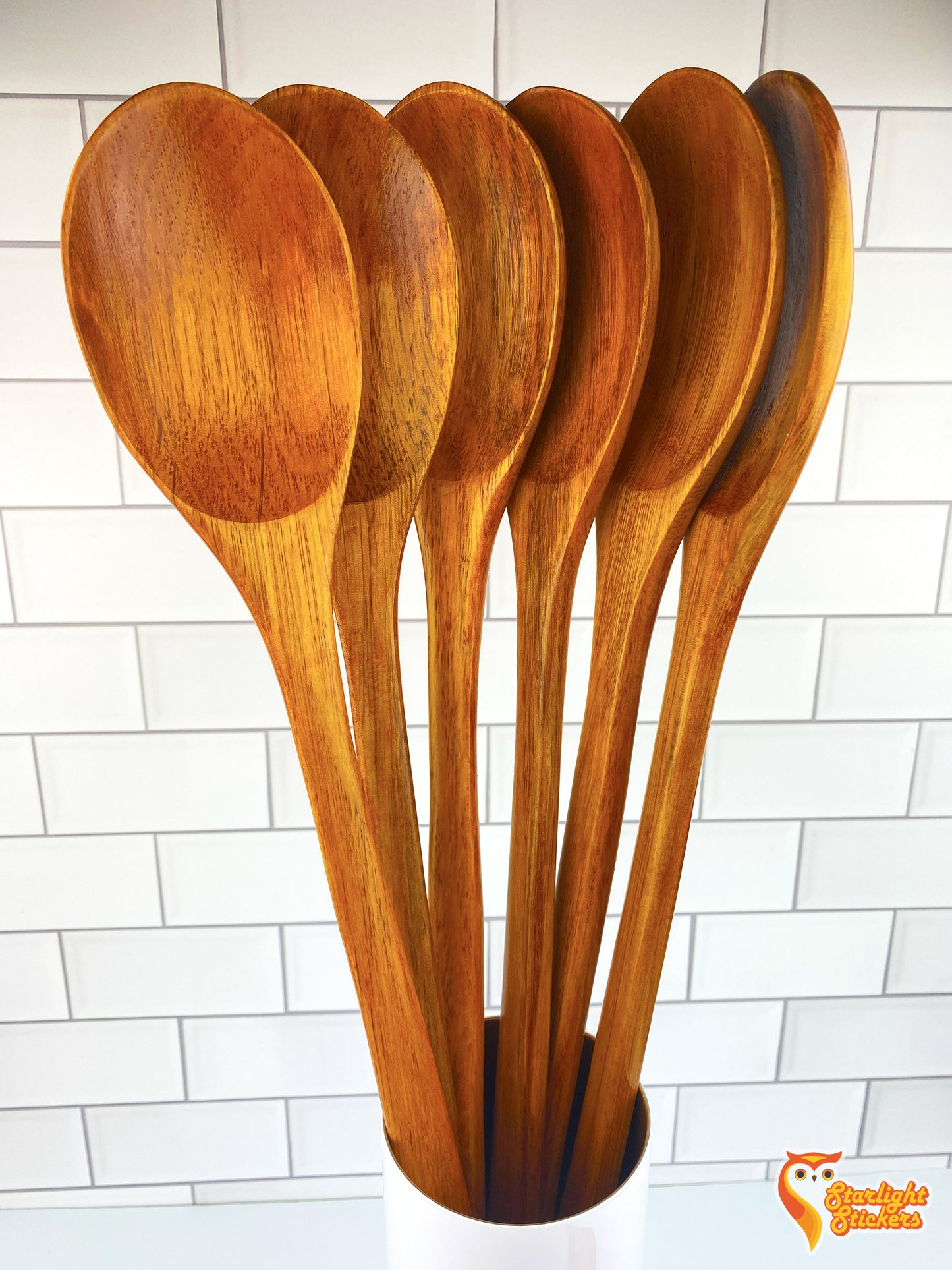 Multiple wooden spoons standing vertically in a cup