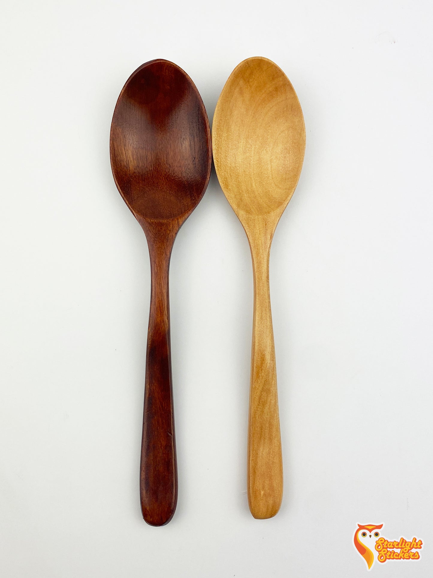 Plain dark wood and light wood spoons next to each other.