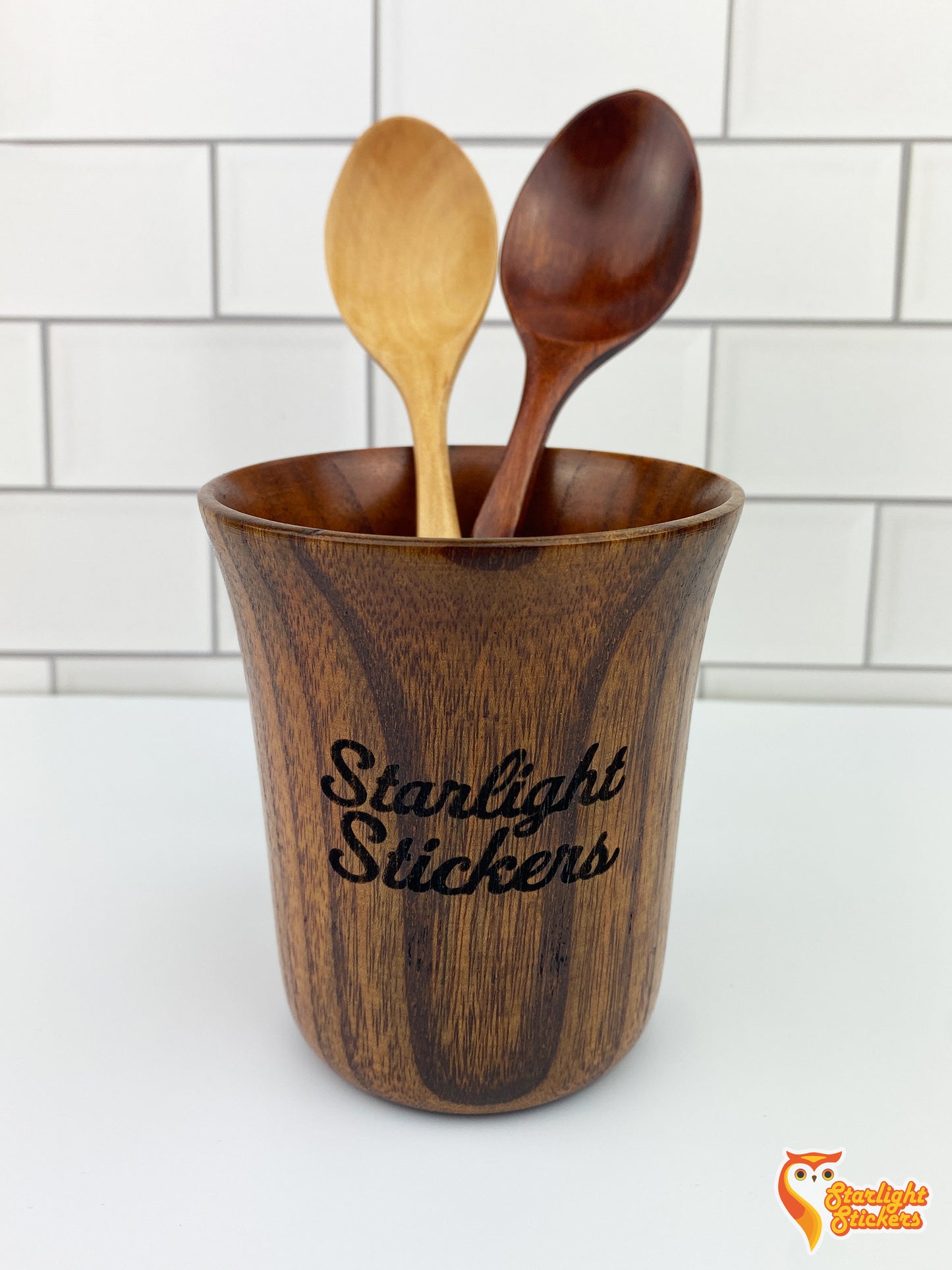 Two spoons in a wooden mug.
