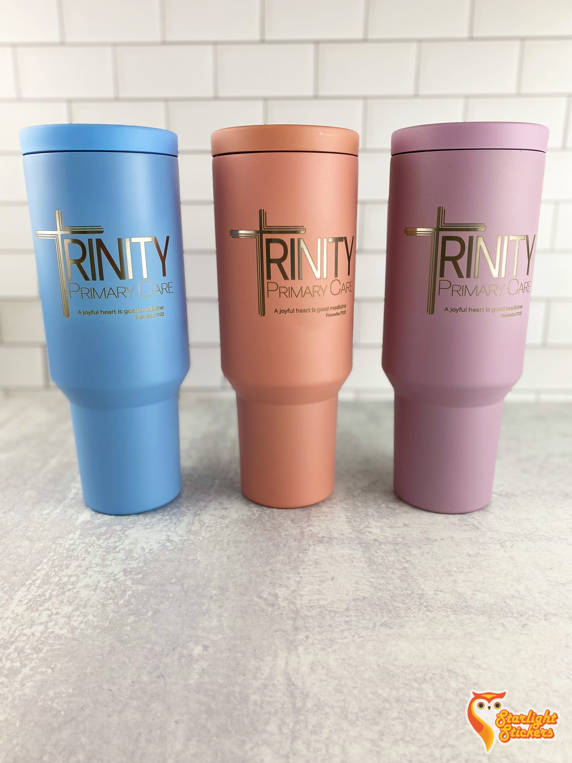 3 Light blue, rose pink and lavender tumblers lined up next to each other.