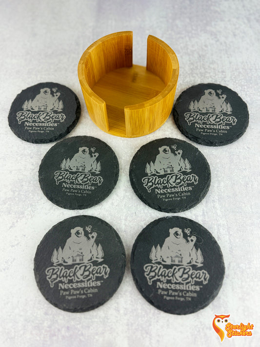 6 circular coasters spread out on a table next to the empty coaster holder.