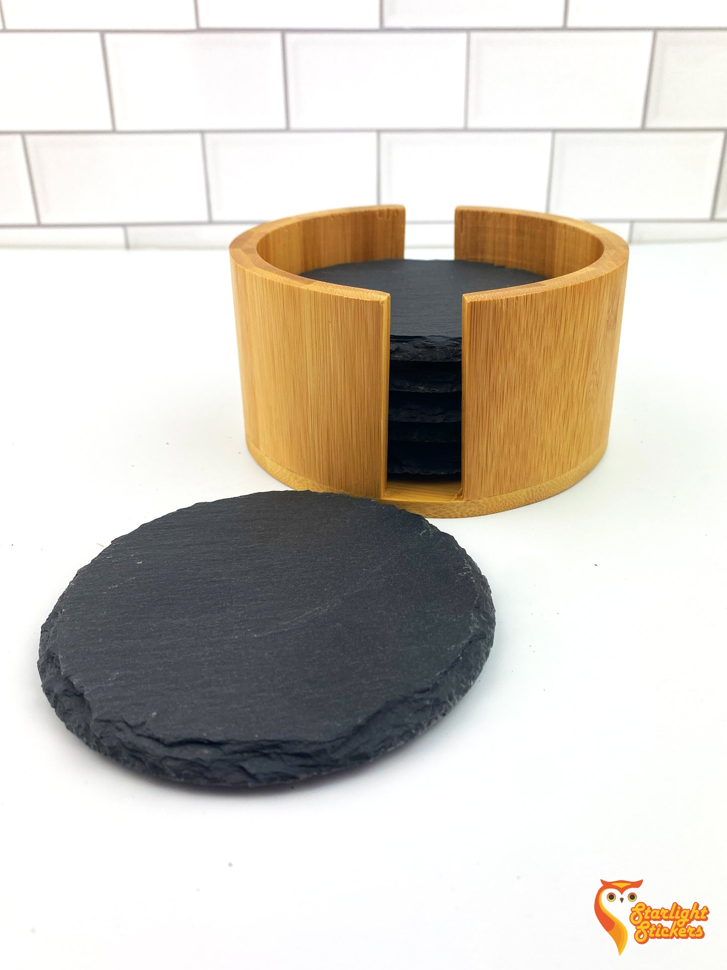 One circular coaster laying next to the almost full coaster holder.