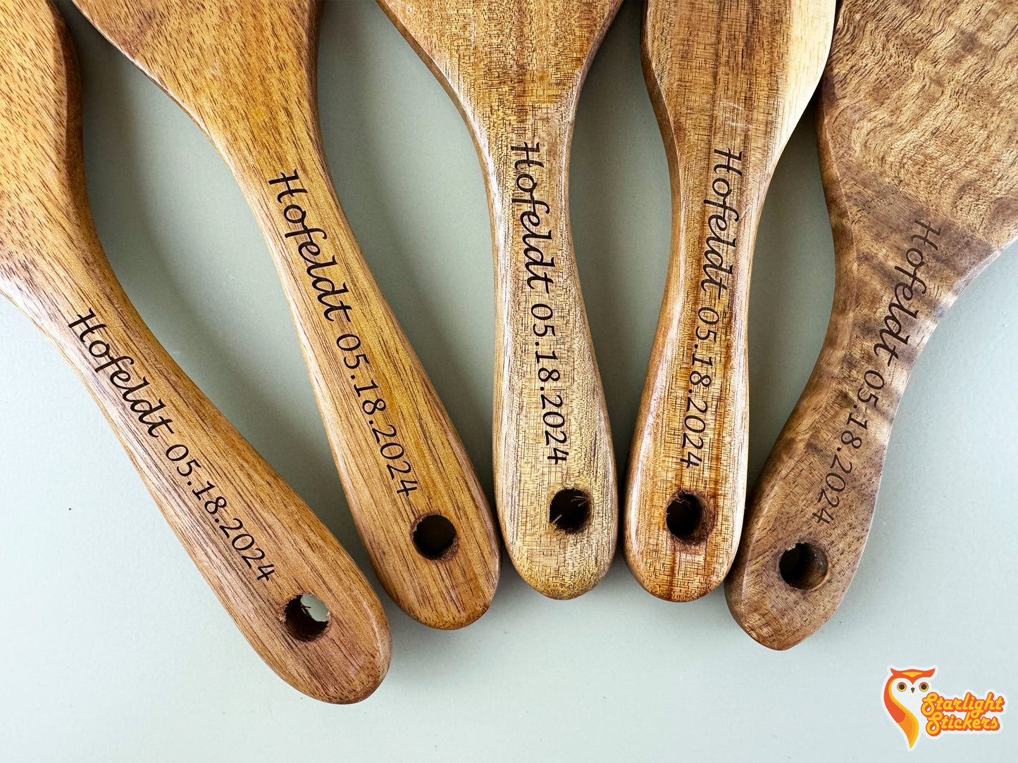 5 engraved spurtle handles next to each other.