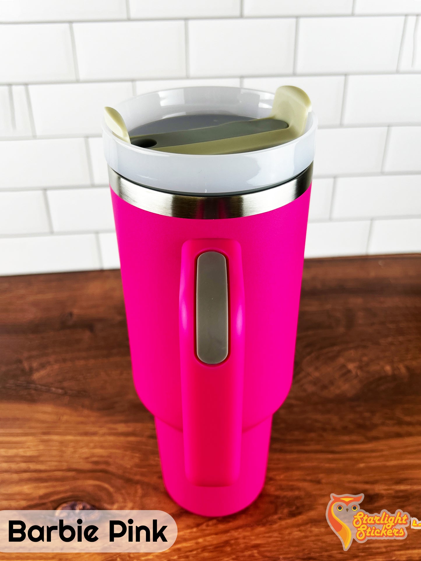 Barbie pink tumbler showing the handle grip on a wooden table.