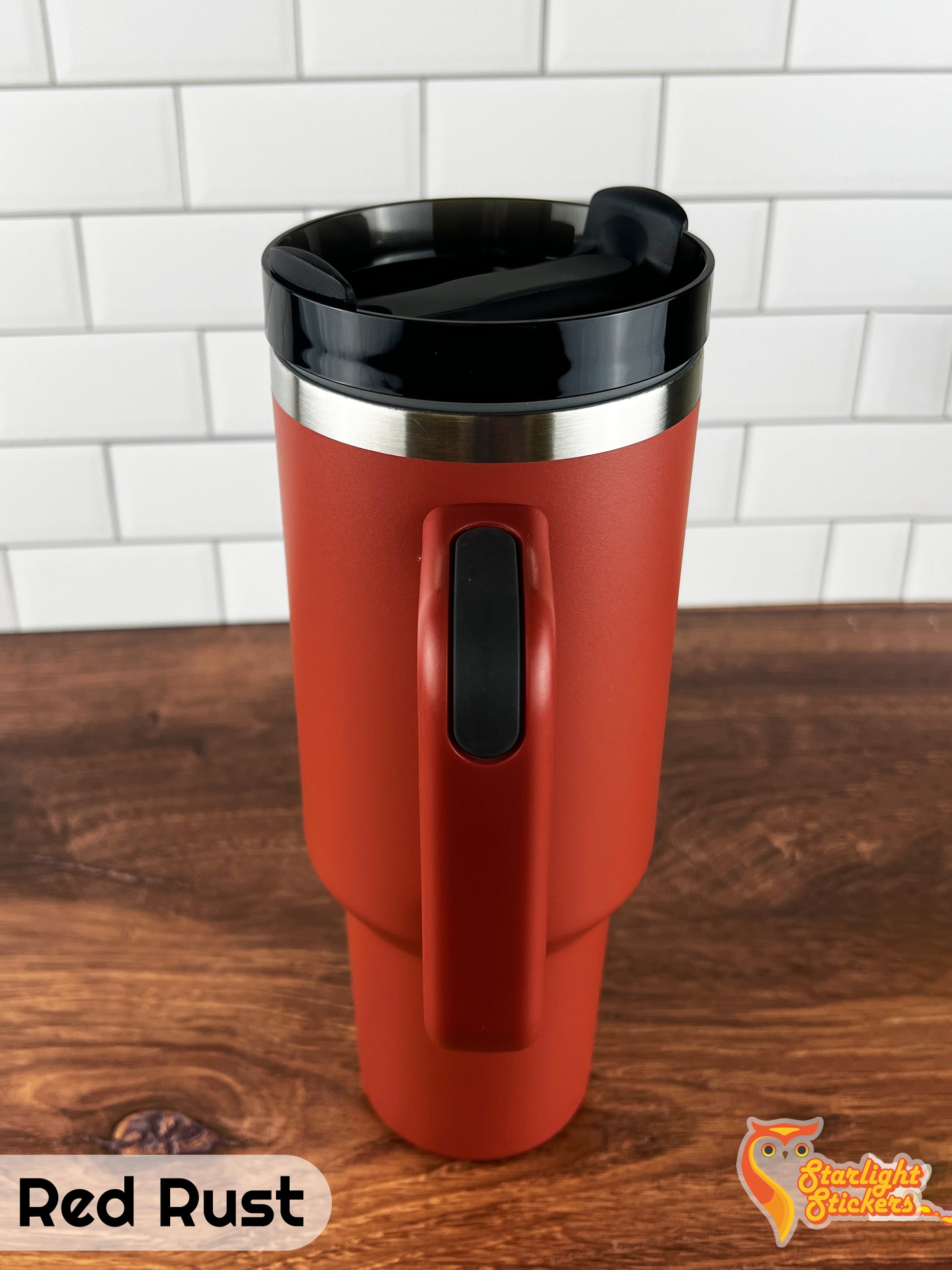Red rust tumbler showing the handle grip on a wooden table.