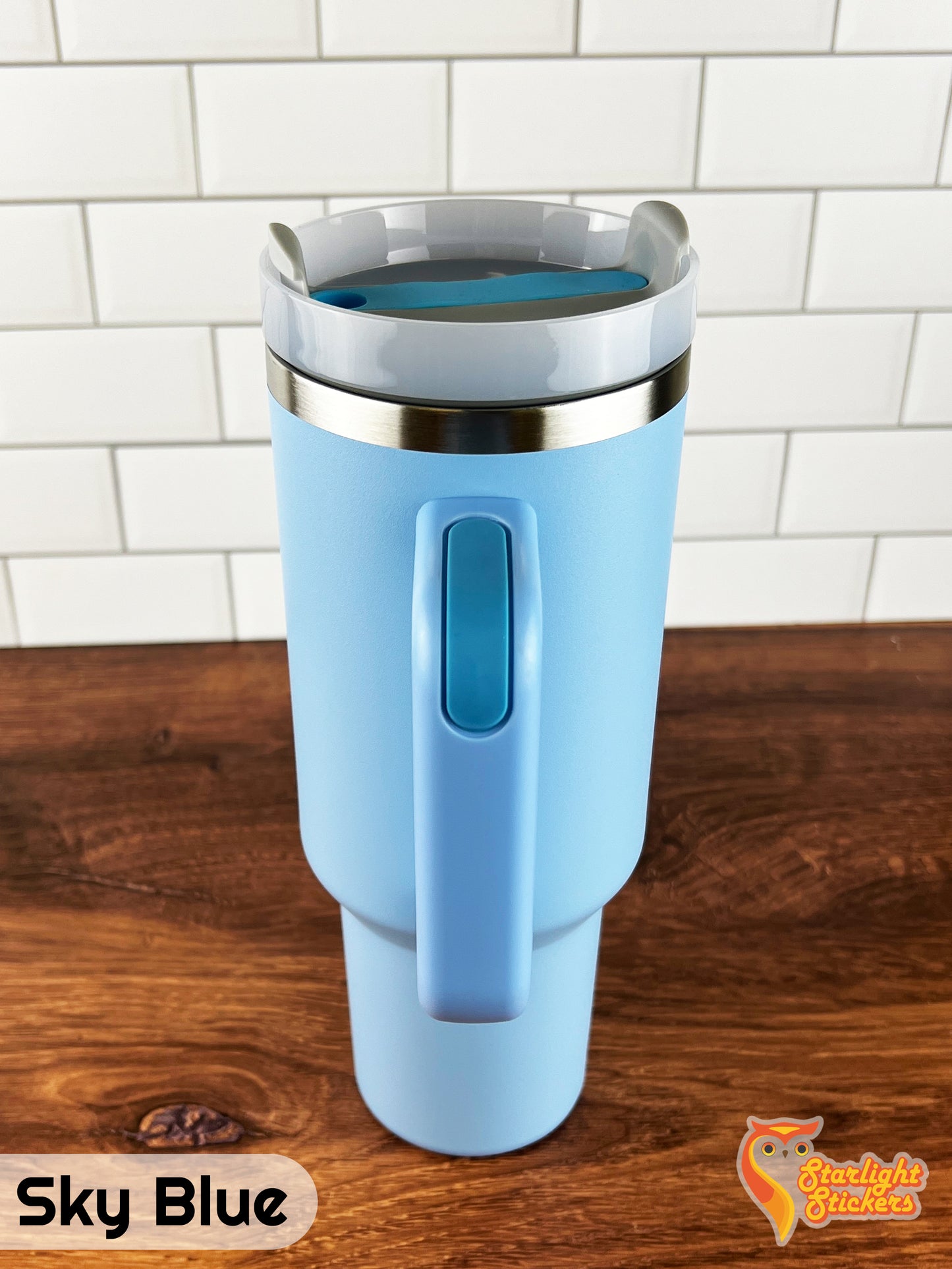 Sky blue tumbler showing the handle grip on a wooden table.