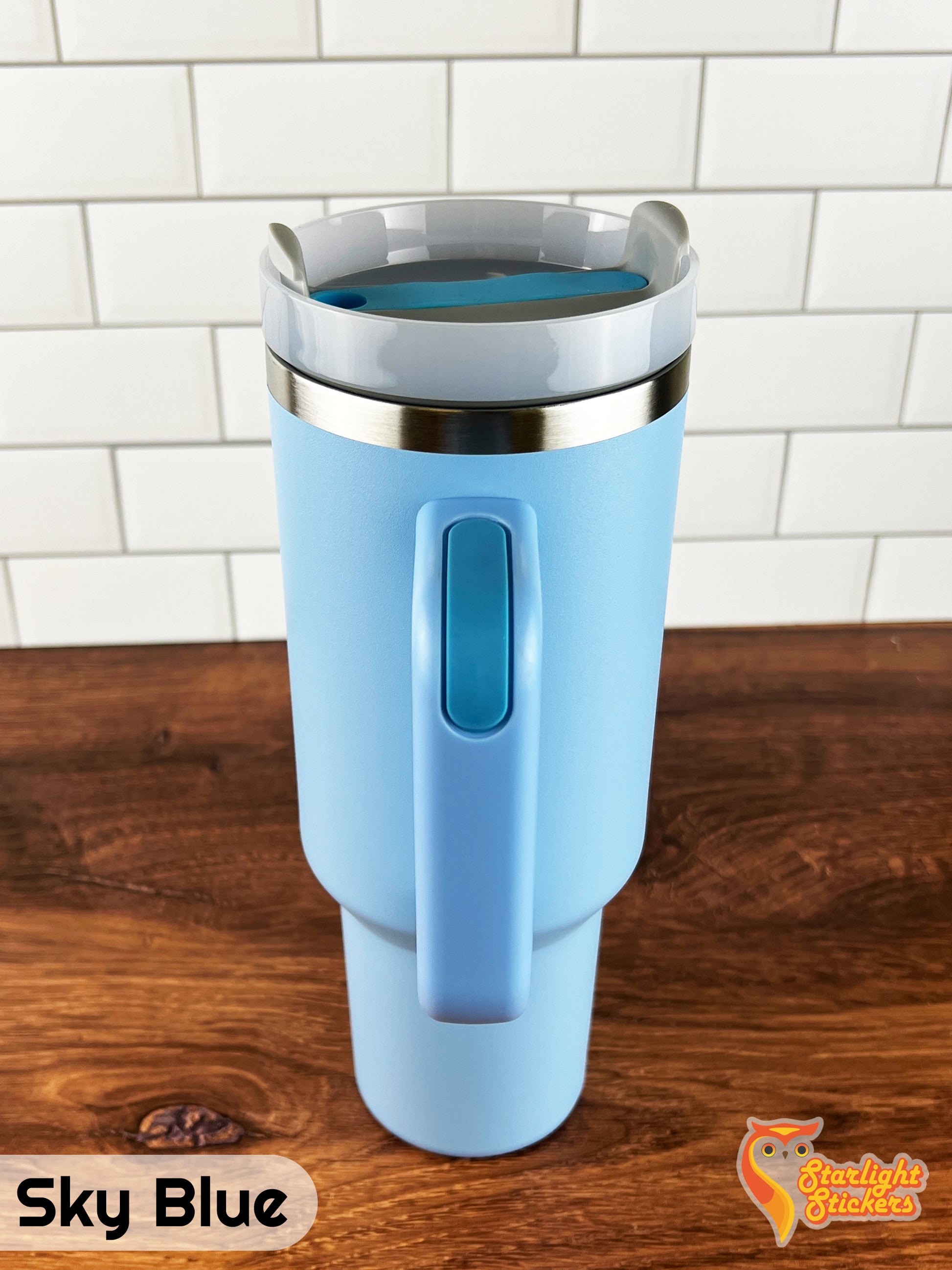 Sky blue tumbler showing the handle grip on a wooden table.