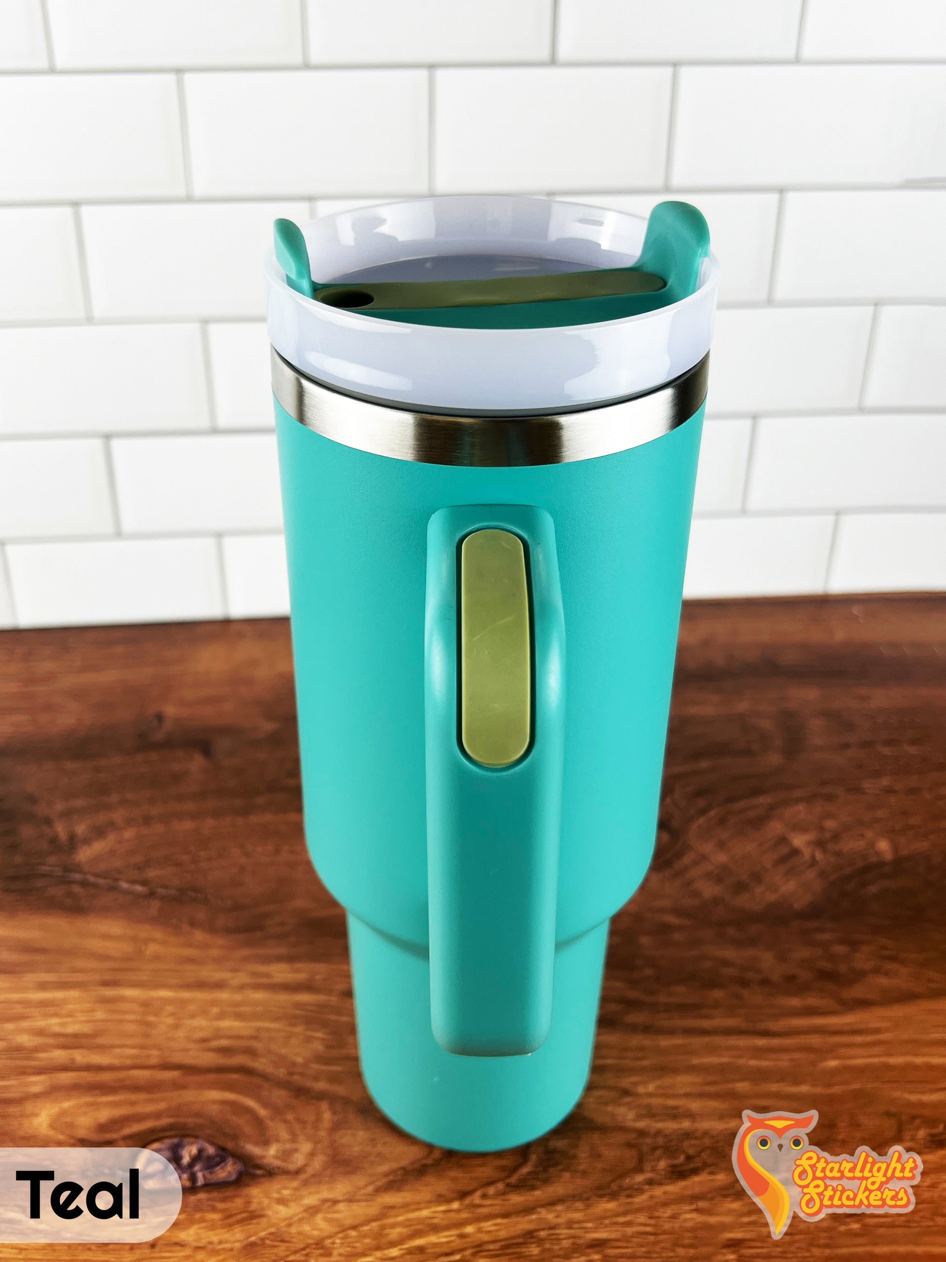 Teal tumbler showing the handle grip on a wooden table.