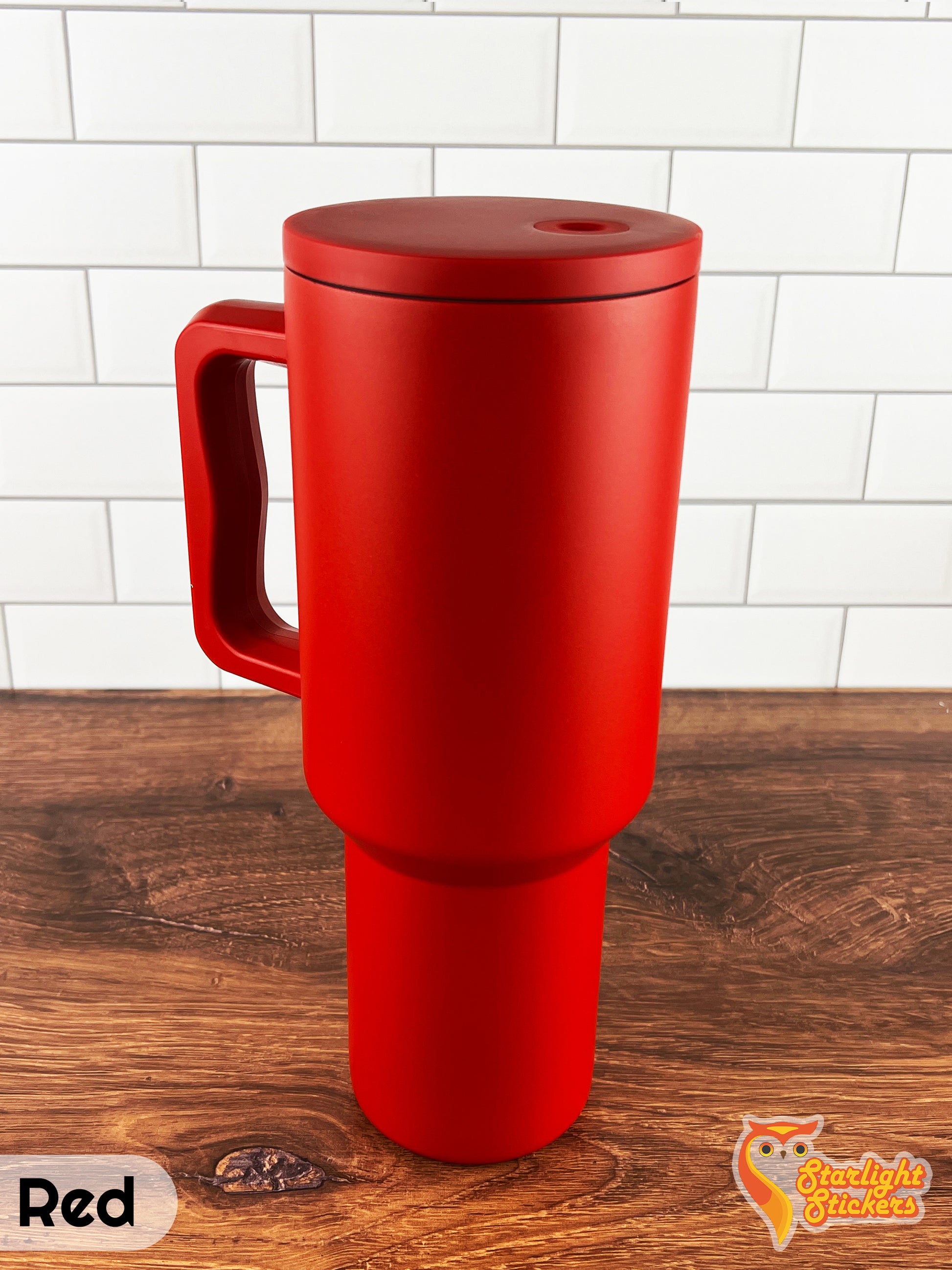 Red tumbler on a wooden table with a white tile background.