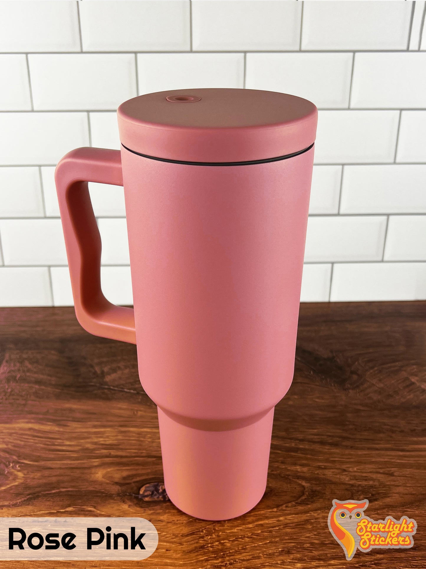 Rose pink tumbler on a wooden table with a white tile background.