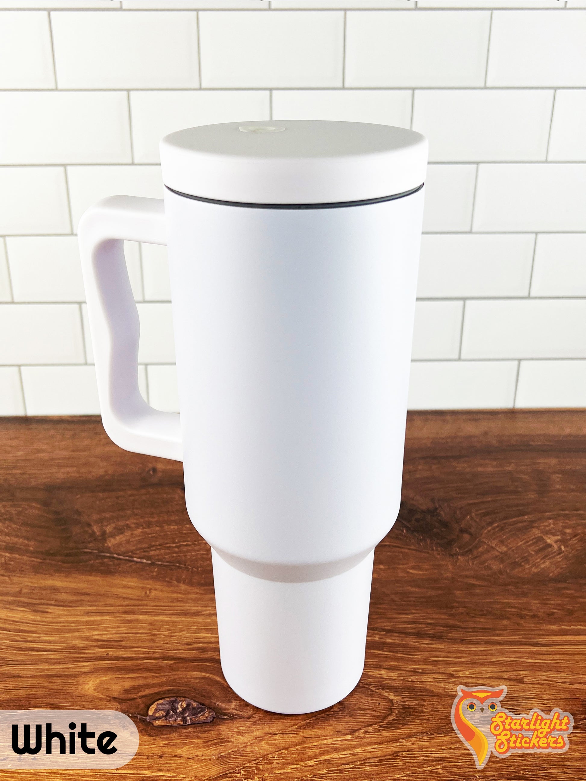 White tumbler on a wooden table with a white tile background.