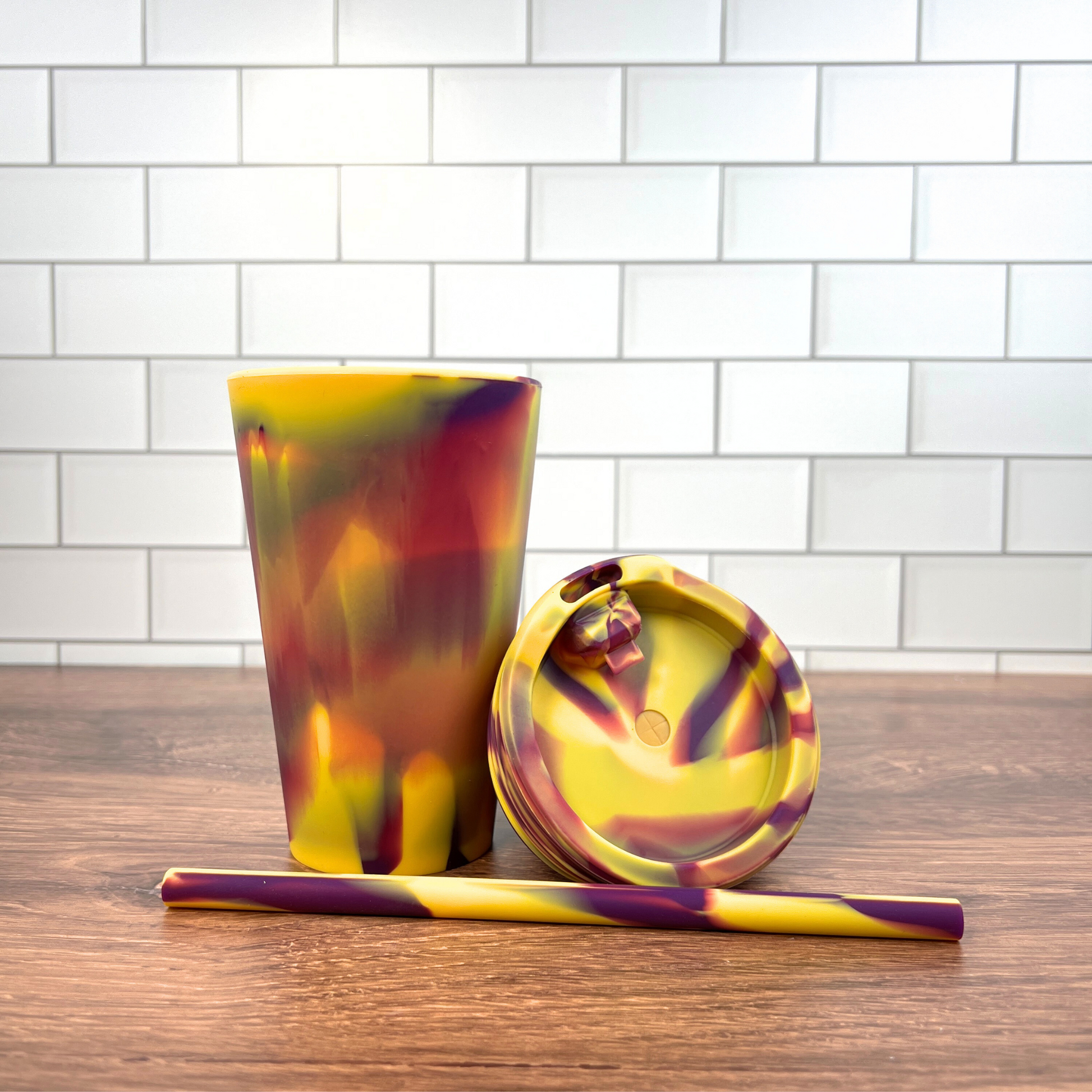 Yellow and purple silicone cup with a matching lid and straw.