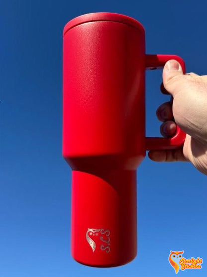 Hand holding red tumbler with blue background