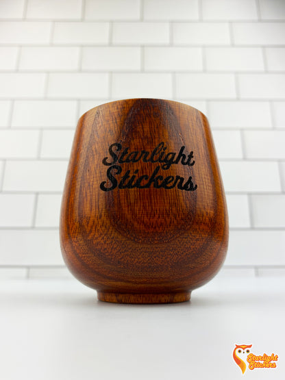 Dark wood cup with, Starlight Stickers, engraved in it. 