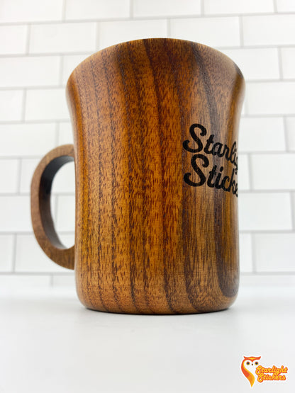 Close up of engraved wooden mug with a white tile background. 