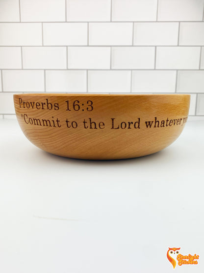 Engraved wooden bowl on a white table with a white tile background. 