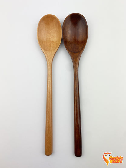 Plain light wood and dark wood spoons next to each other with a white background. 