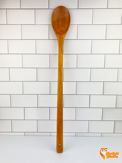 Wooden spoon up against white tile background