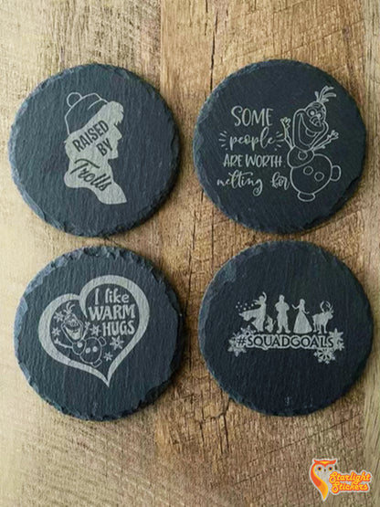 4 circular coasters with Frozen engravings on a wooden table.