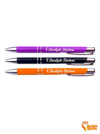 Purple, black, and orange engraved pens with a white background. 